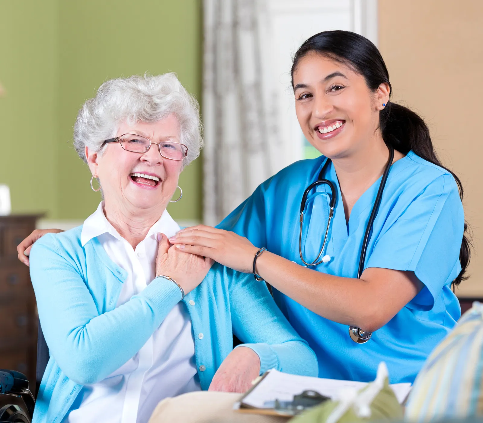 Smiling nurse with elderly woman at home