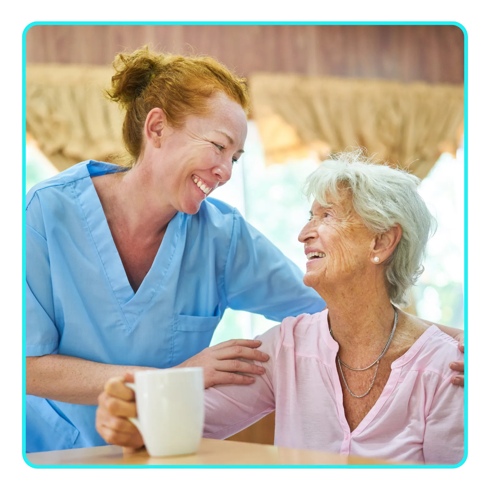 Caregiver smiling with elderly woman holding mug