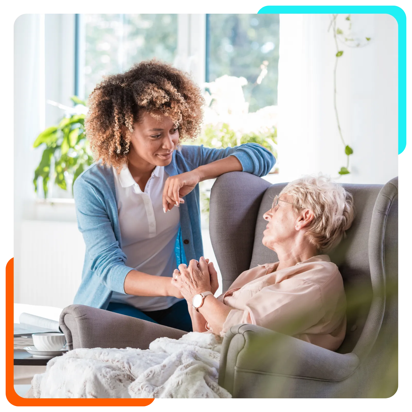 Caregiver comforting older woman in armchair