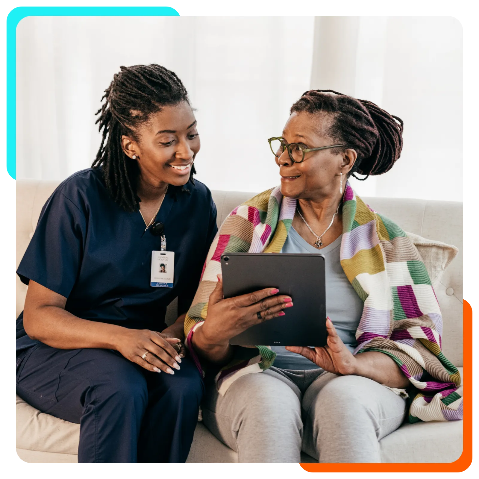 Caregiver and elderly woman using tablet together