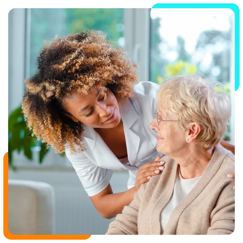 Caregiver comforting elderly woman at home