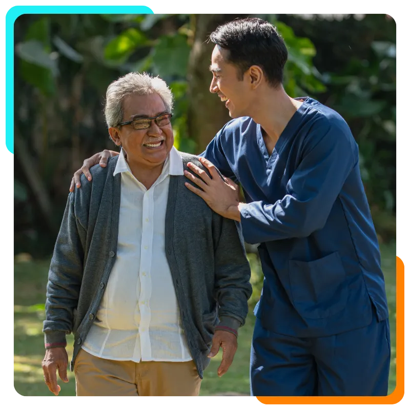 Smiling caregiver walking outdoors with elderly man