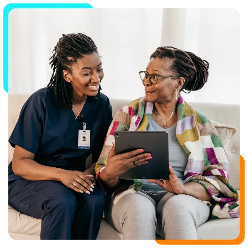 Caregiver and woman smiling while using tablet