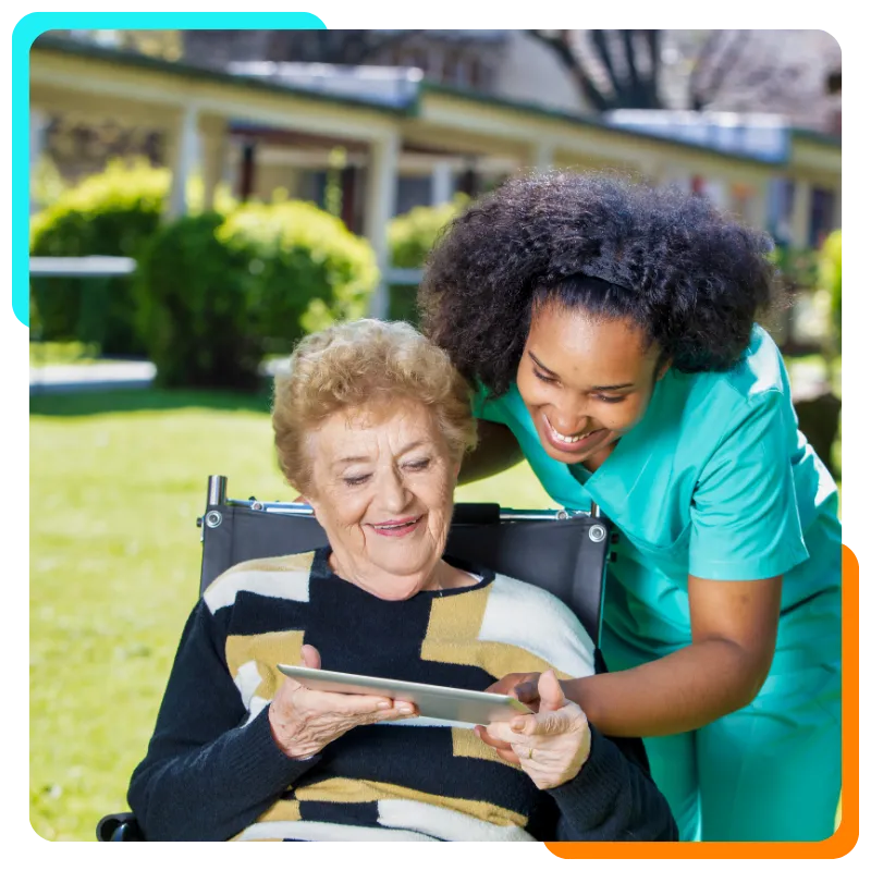 Caregiver helping elderly woman use tablet