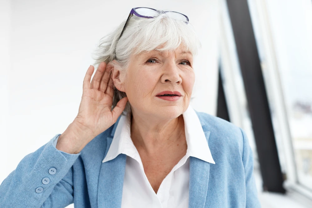 Senior woman cupping hand to ear