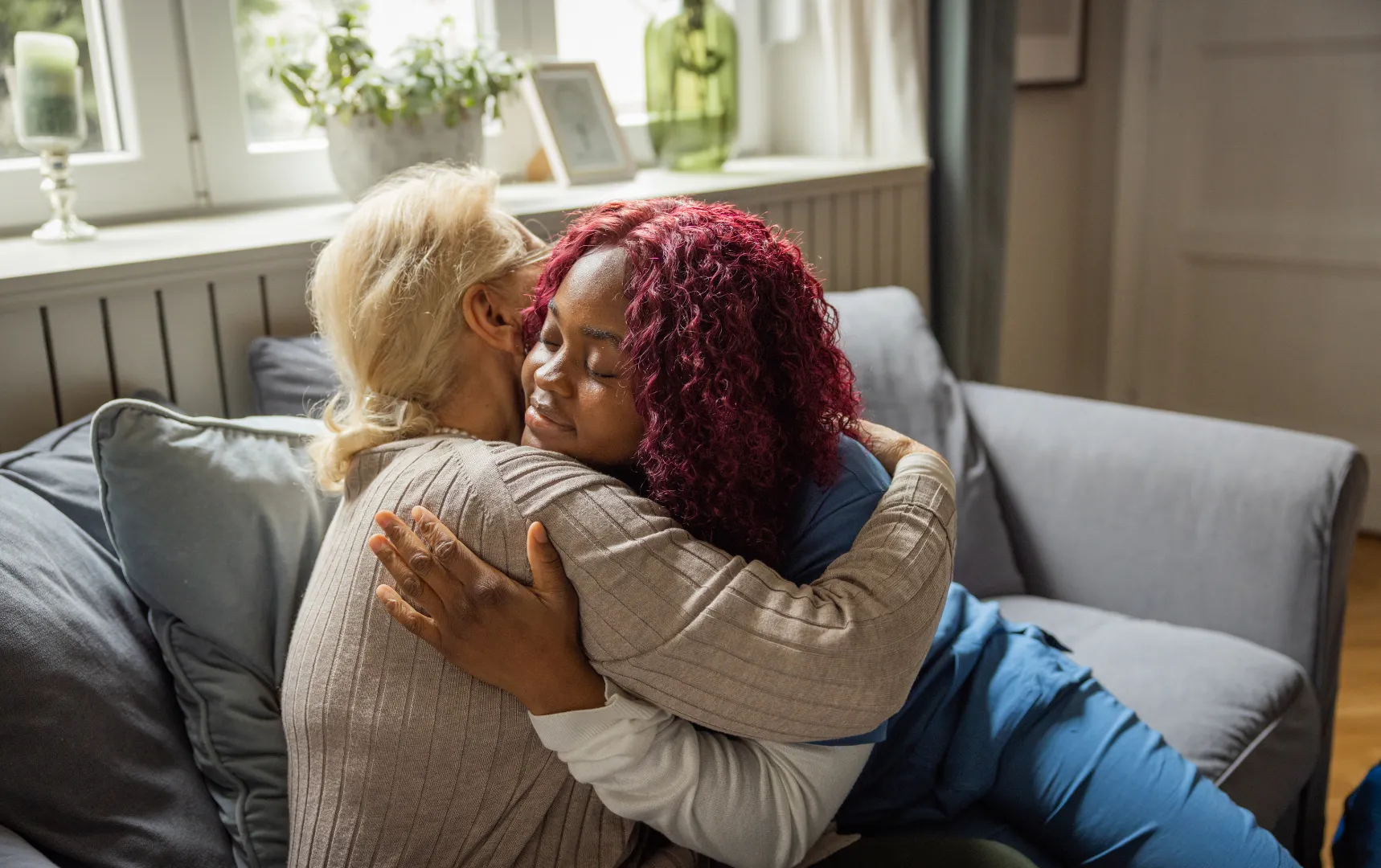 Two people embracing on a living room couch