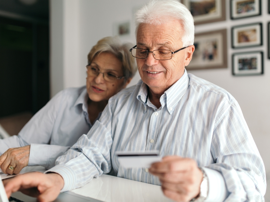 Senior couple shopping online with credit card