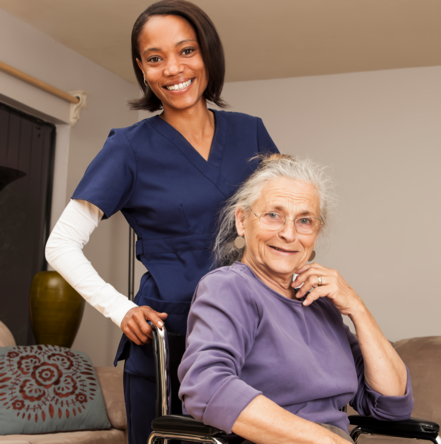 Smiling caregiver with elderly woman in wheelchair