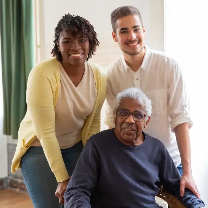 Smiling elderly man with two family members