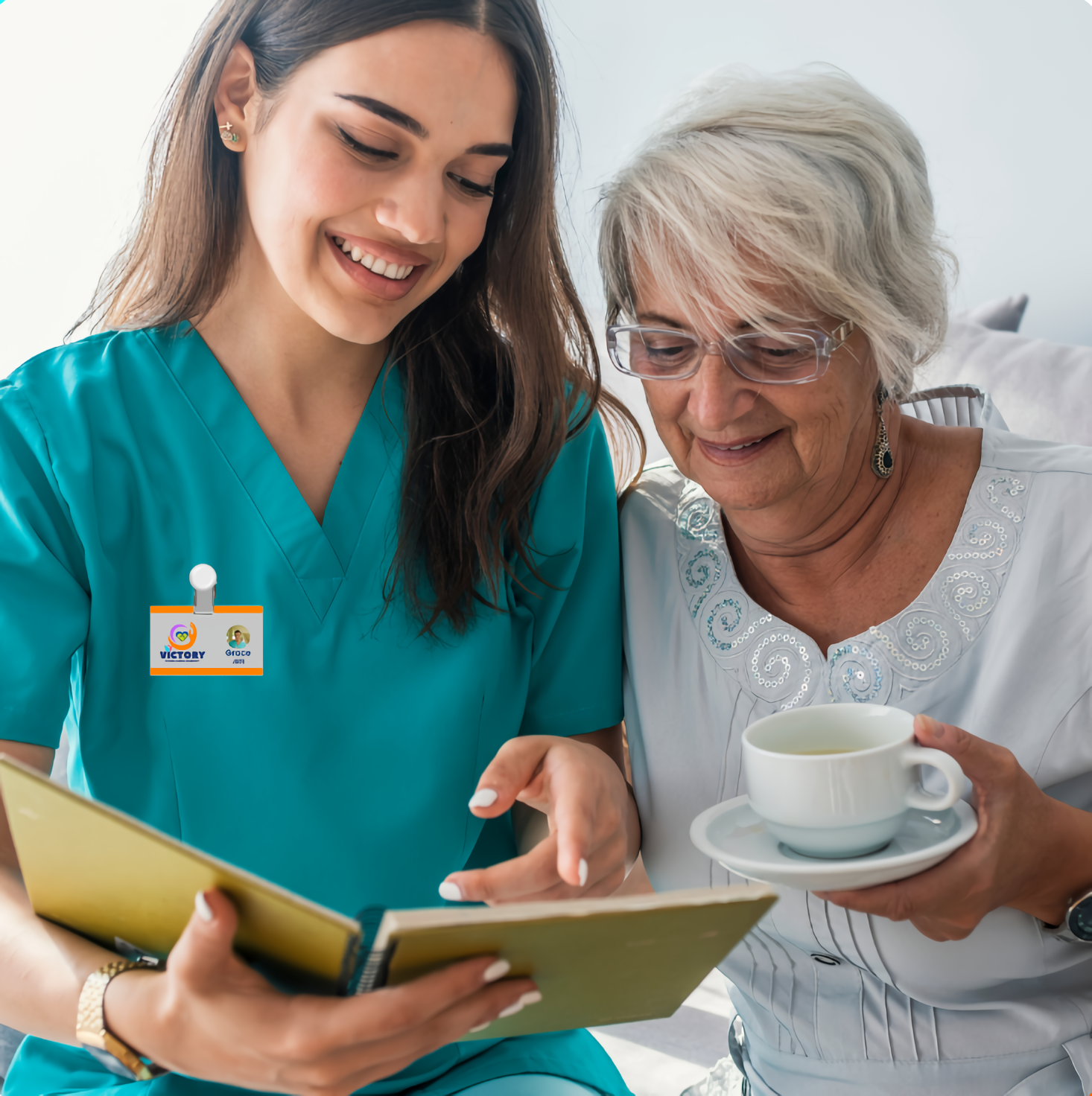 Caregiver and elderly woman reading together