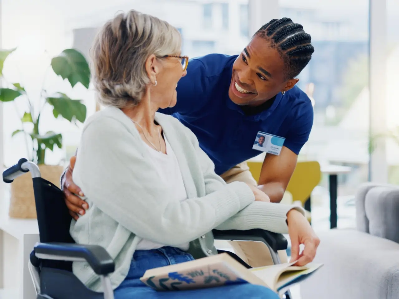 Smiling caregiver with elderly woman in wheelchair