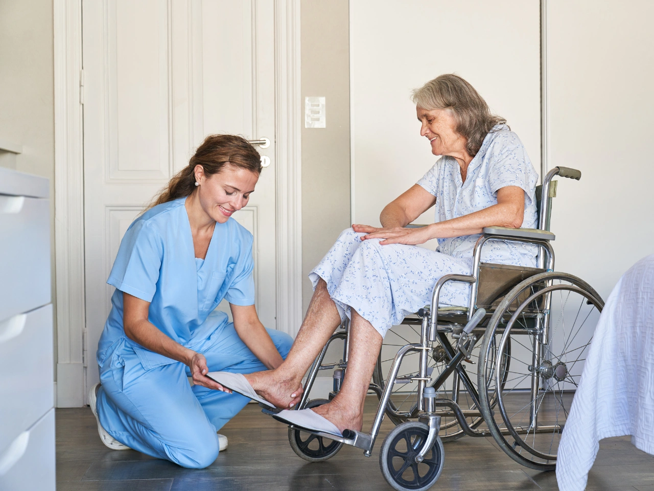 Nurse assisting elderly woman in wheelchair