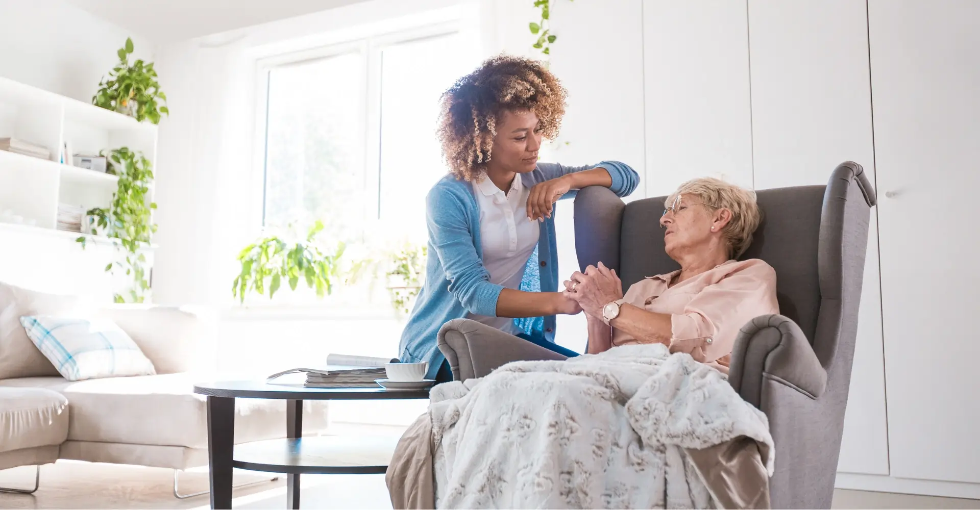 Caregiver comforting senior woman at home